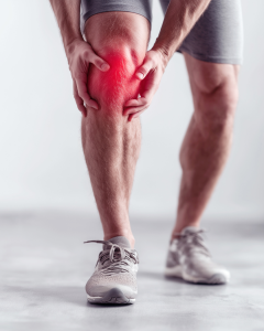 Person holding their knee with a red highlighted area indicating bursitis pain and inflammation